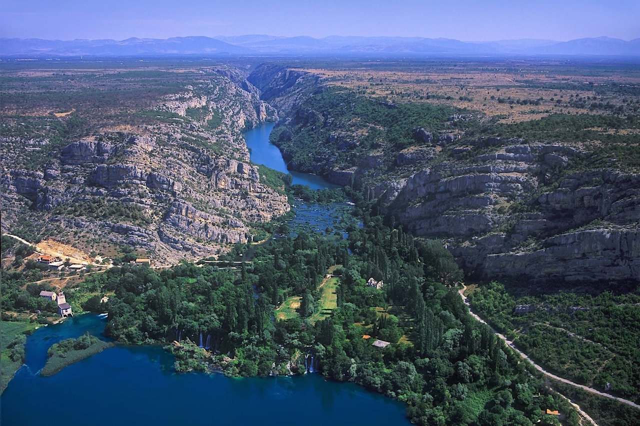 Aerial view of river canyon with waterfalls and lush green nature in Croatia