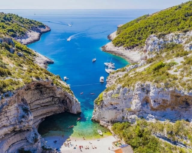 Drone view of the famous Stiniva Cove on Vis Island, Croatia, a secluded Adriatic bay accessible by boat and one of the most iconic Dalmatian beaches.