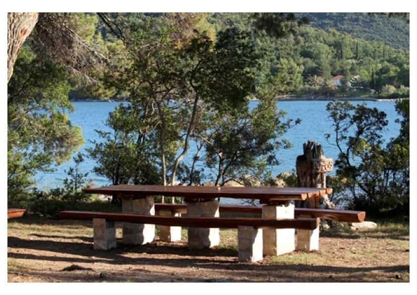 Seaside wooden table and benches on a private peninsula overlooking Ston Bay, Croatia